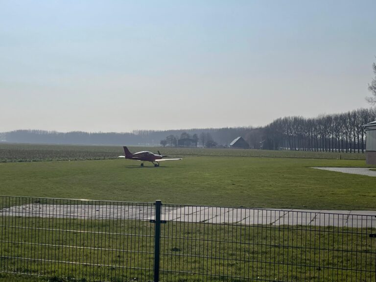 small airplane on a grass runway